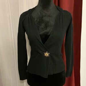 This black sweater comes with a beautiful brooch.